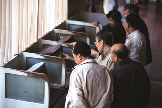 Investors follow financial information at a securities brokerage in Shanghai. The Shanghai Composite was up 2.15% at 3,018.80 points yesterday.