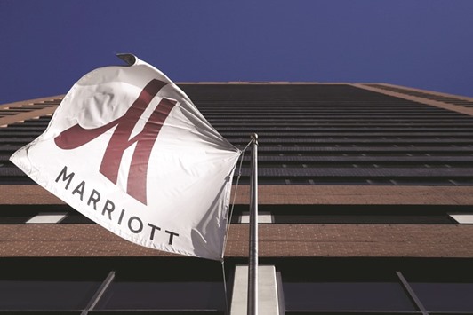 A Marriott flag flutters at the entrance of the New York Marriott Downtown hotel in Manhattan. Under the terms of the new offer, Starwood shareholders will receive $21 in cash and 0.80 shares of Marriott common stock for each Starwood share, according to a statement yesterday.