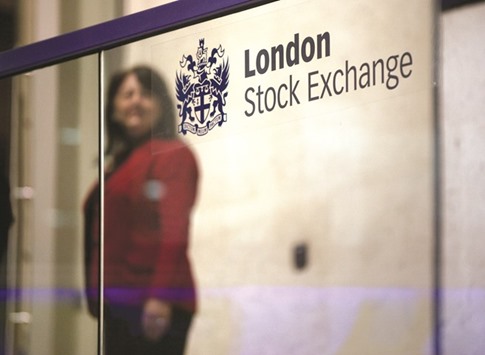 A visitor passes a sign inside the London Stock Exchange. The FTSE 100 closed up 0.1% to 6,194 points yesterday.