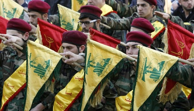 Hezbollah members hold their flags in the southern Lebanese town of Kfour, in the Nabatiyeh district, during the funeral of a Hezbollah fighter, Mohammed Hassan Nehme, who was killed in Syria.