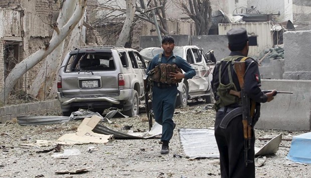 An Afghan policeman runs during the gunfire in front of the Indian consulate in Jalalabad on Wednesday.