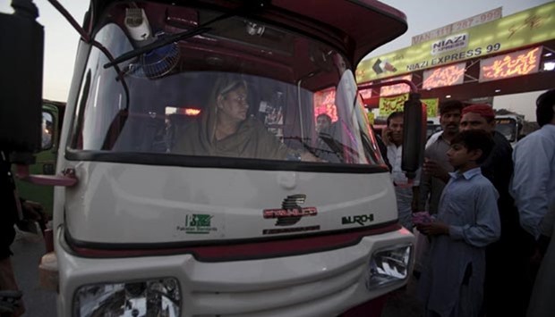Pink Rickshaw driver Parveen Bibi looks for prospective passengers in Lahore.