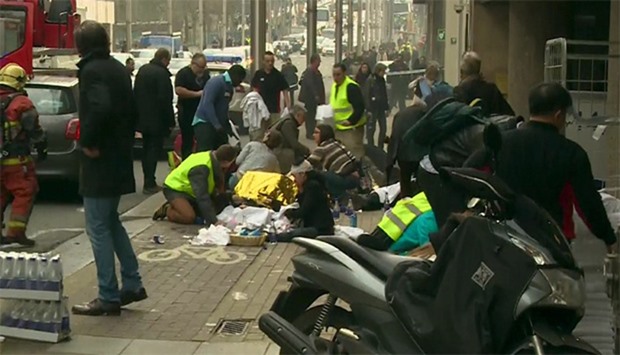Rescue workers treat victims outside the Maelbeek metro station after a blast, in Brussels