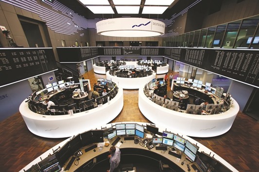Traders monitor data on computer screens at the Frankfurt Stock Exchange. The DAX 30 closed up 0.4% to 9,990 points yesterday.