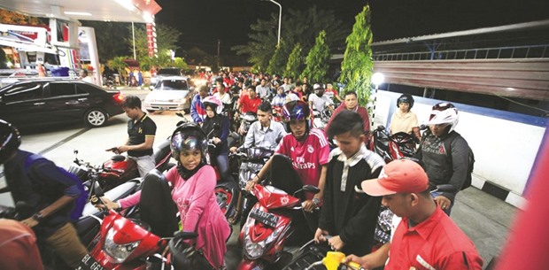 Dozens of scooter drivers queue to refuel at a gas station in Jakarta. An investment grade rating from S&P is a top priority for President Joko Widodou2019s administration as it would reduce Indonesiau2019s risk premium and bring down government bond yields for the country.