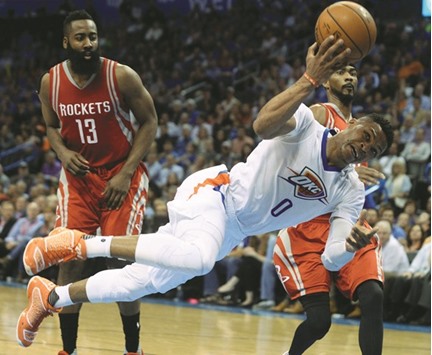 Oklahoma City Thunder guard Russell Westbrook (foreground) drives to the basket against Houston Rockets guard James Harden (left) and Houston Rockets guard Corey Brewer (33) during the fourth quarter of their NBA game in Oklahoma City, Oklahoma, on Tuesday. (USA TODAY Sports)