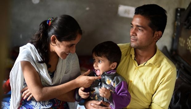 Tuberculosis patient Sonu Verma sits with his wife and child at his home in Sonipat.