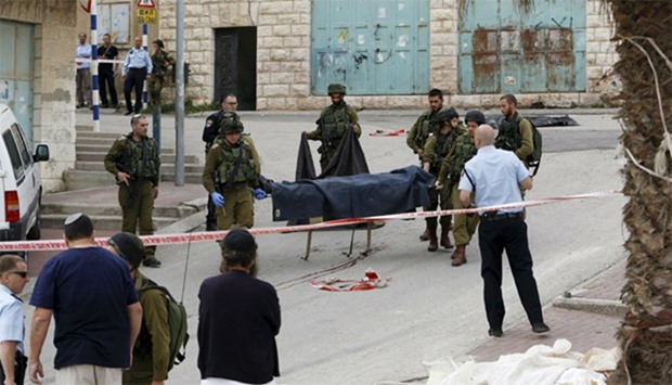 Israeli soldiers carry the dead body of one of two Palestinians