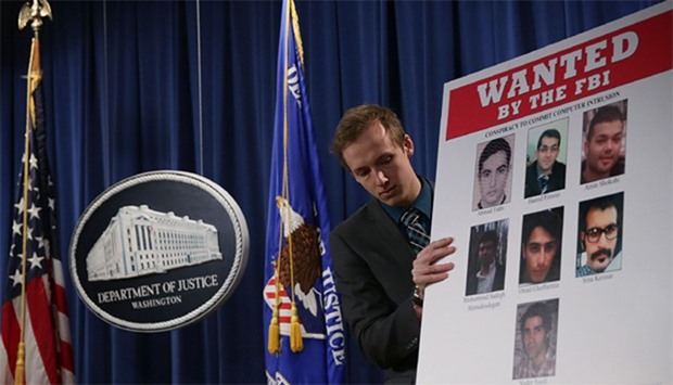 A Department of Justice employee put up a poster of the seven indicted hackers