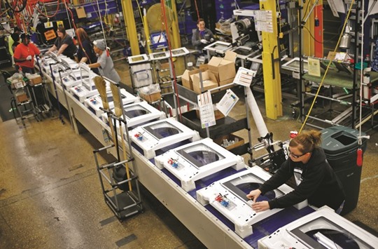 Workers assemble washing machines at the Whirlpool Corp manufacturing facility in Clyde, Ohio. Bookings for goods and materials meant to last at least three years declined 2.8% in February after a 4.2% gain that was less than previously reported, Commerce Department data showed yesterday.