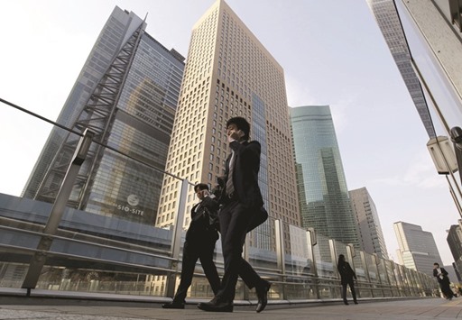 Businessmen walk in Tokyou2019s business district. Most Japanese companies think the central banku2019s shock adoption of a negative interest rates policy has been a bad move that will hit business and consumer sentiment, a Reuters poll showed yesterday.