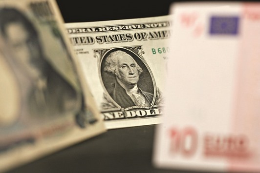 A US one dollar bill is photographed with yen and euro notes in New York (file). Hints the US could raise interest rates next month drove the dollar higher yesterday; a stronger greenback makes it more expensive for investors using other currencies to buy dollar-priced commodities, and raw materials.