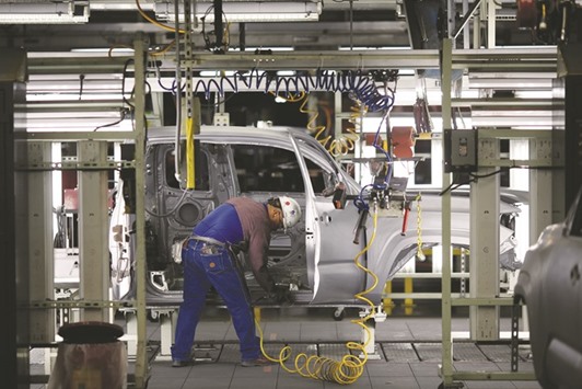A worker sands down the edges of a truck frame on the assembly line at the Toyota Motor Corp manufacturing facility in San Antonio, Texas. The fourth quarter GDP of the US increased at a 1.4% annual rate instead of the previously reported 1.0% pace, the Commerce Department said yesterday.