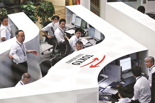 Traders work at the Tokyo Stock Exchange. The Topix index closed up 0.8% to 1,366.05 points yesterday.