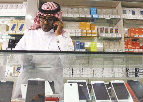 A Saudi vendor speaks on his phone as he waits for customers at a mobile shop in Riyadh on Monday. In early March, the Ministry of Labour announced that within six months foreigners would be banned from selling and maintaining mobile phones and accessories for them, in an effort to keep open more jobs for Saudi citizens.
