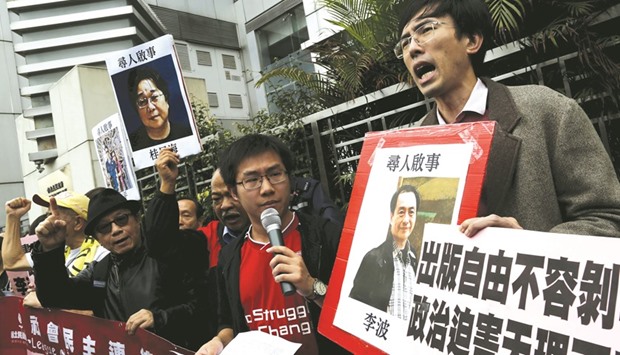Pro-democracy demonstrators hold up a portrait of Causeway Bayu2019s Lee Bo (right) during a protest to call for an investigation behind the disappearance of five staff members of a Hong Kong publishing house and bookstore, outside the Chinese liaison office in Hong Kong in this January 3, 2016 file photo.