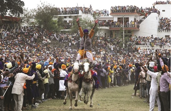 A u201cNihangu201d, or Sikh warrior, rides two horses as he performs during the Holla Mohalla festival in Anandpur Sahib, Punjab. u201cHola Mohallau201d, or the festival of Nihangs, is celebrated during the festival of Holi.