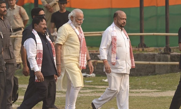 Prime Minister Narendra Modi is accompanied by Asom Gana Parishad leader Atul Bora as he arrives to attend a BJP rally at Bokakhat in Golaghat district of Assam yesterday.