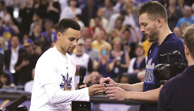 Stephen Curry (left) of the Golden State Warriors gives Dallas Mavericksu2019 David Lee his championship ring from last season before their game at Oracle Arena in Oakland, California on Friday. (AFP)