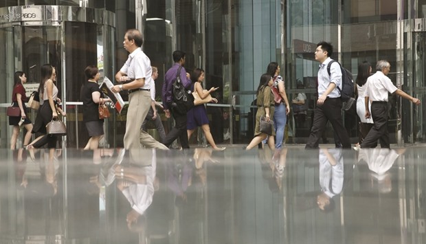 Office-goers during morning peak hour in the central business district in Singapore. Finance Minister Heng Swee Keat, in his first budget to Parliament, pledged support for companies facing labour constraints and a faltering global outlook, promised higher wages for low-income earners and more assistance for elderly and needy households.
