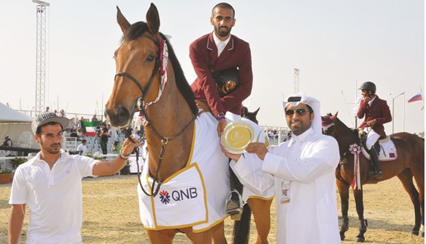 Qataru2019s Rashid Towaim al-Marri receives the trophy after winning the CSI2* 145cm class event yesterday.