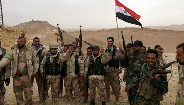 Forces loyal to Syria's President Bashar al-Assad flash victory signs in Palmyra