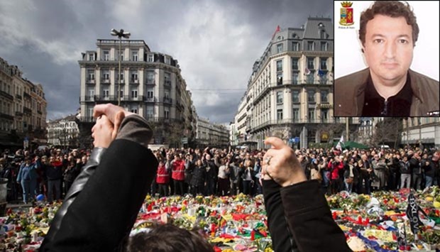 People hold hands as they gather at the makeshift memorial on the Place de la Bourse Square in Brussels on Sunday to pay tribute to the victims of the terror attacks which killed 31 people and injured over 300. Inset, Djamal Eddine Ouali.