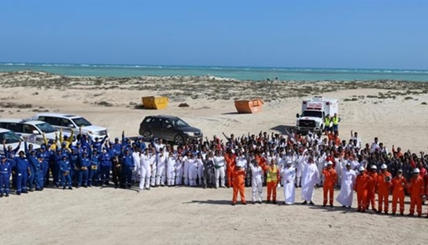 Officials and volunteers pose for a photo after the beach clean-up.