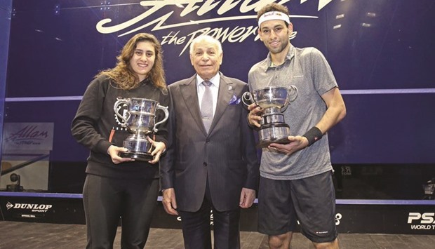 Egyptu2019s Nour El Sherbini (left) and Mohamed El Shorbagy pose with their trophies after winning the British Open squash titles yesteday.