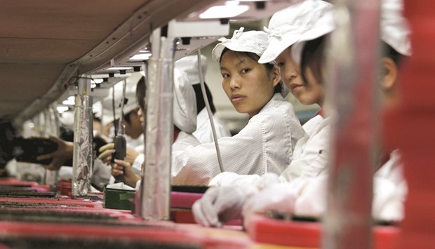 Workers are seen inside a Foxconn factory in the township of Longhua in the southern Guangdong province. The company plans to help Sharp pay back the u00a5510bn in loans at an interest rate no higher than 0.6%.