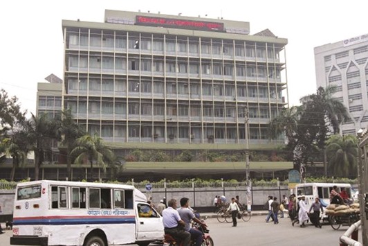 Commuters pass by the front of the Bangladesh central bank building in Dhaka.