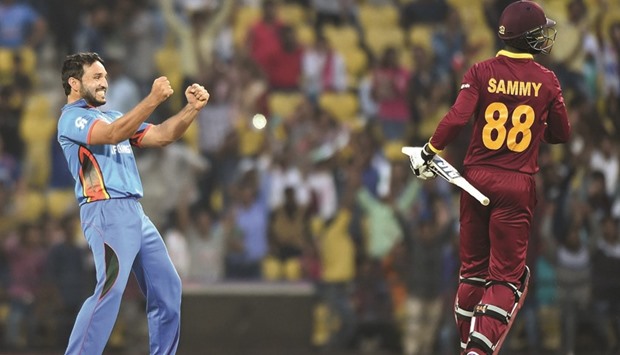 Afghanistan bowler Gulbadin Naib (L) celebrates after taking the wicket of West Indiesu2019s batsman Darren Sammy yesterday.