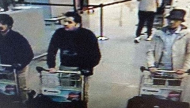 The footage shows the man wearing a hat and white jacket pushing a trolley with a large bag through the departure hall, next to suicide bombers Ibrahim El Bakraoui and Najim Laachraoui.