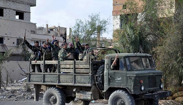 Syrian forces flash victory signs in Palmyra city.