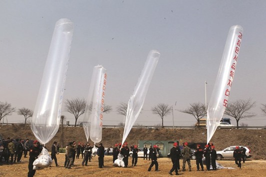 South Korean conservative activists launch large balloons carrying anti-Pyongyang leaflets at a field near the demilitarised zone dividing the two Koreas in Paju yesterday.