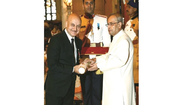 President Pranab Mukherjee presents the Padma Bhushan Award to Bollywood actor Anupam Kher in New Delhi yesterday.