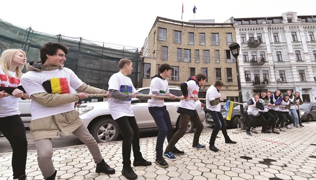 A group of Ukrainian activists wearing masks depicting Russian President Vladimir Putin play tug of war with others wearing t-shirts decorated with EU countriesu2019 flags during a demonstration near the Dutch embassy in Kiev. An Ukrainian flag is placed at the centre of the rope. Demonstrators called the Dutch people to  support Ukraine ahead of a referendum on an association agreement of the EU with Ukraine, which will take place next month.