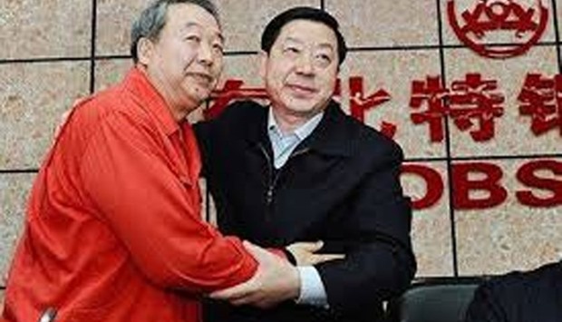 File picture of Yang Hua (right) and former chairman of the Northeast Special Steel