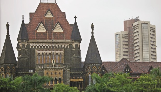 The Bombay Stock Exchange (right) is seen behind the Bombay High Court building in Mumbai. Analysts have lowered the 12-month projected earnings growth estimate for the Sensex by 11% since May 2015, the most since the 23% cut in 2009, data compiled by Bloomberg show.