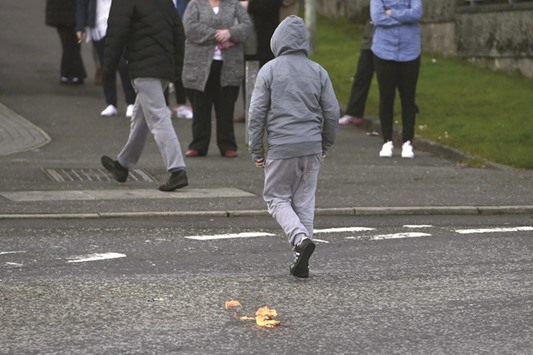 A boy walks away after throwing a petrol bomb before a 32 County Sovereignty Movement parade in Creggan Cemetery for a commemoration of the 100 year anniversary of the 1916 Irish Easter Rising, in Londonderry, Northern Ireland.