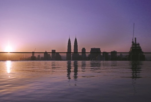 The Petronas Towers are reflected in a swimming pool as the sun rises over Kuala Lumpur, Malaysia yesterday.