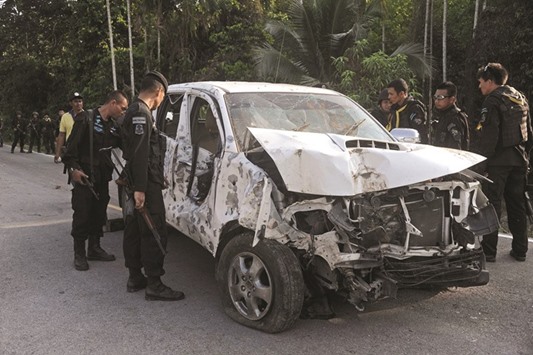 Thai rangers inspect the site of a roadside bomb attack targeting a car carrying patrolling police officers and triggered by suspected separatist militants in the Rangae district of the southern province of Narathiwat yesterday.