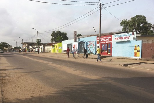People walk past shuttered shops in Brazzaville yesterday.