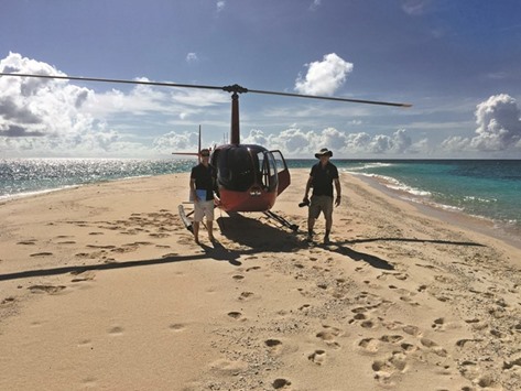 Aerial surveyors James Kerry and Terry Hughes with the helicopter they use to survey the reef.
