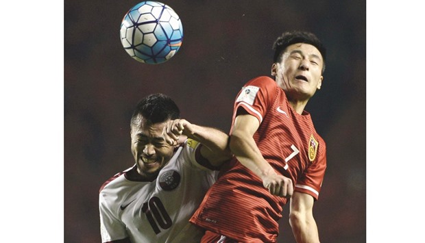 Wu Lei (R) of China fights for the ball with Rodrigo Tabata of Qatar during their Group C Asian qualifying match in Xiu2019an yesterday
