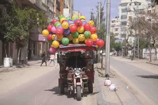 A Palestinian man rides a tuk-tuk loaded with plastic footballs in Gaza City yesterday.