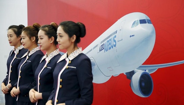 Staff members stand in front of a wall bearing the image of the Airbus A330 plane at a ground-breaking ceremony for the Airbus A330 completion and delivery centre in Tianjin on Wednesday.