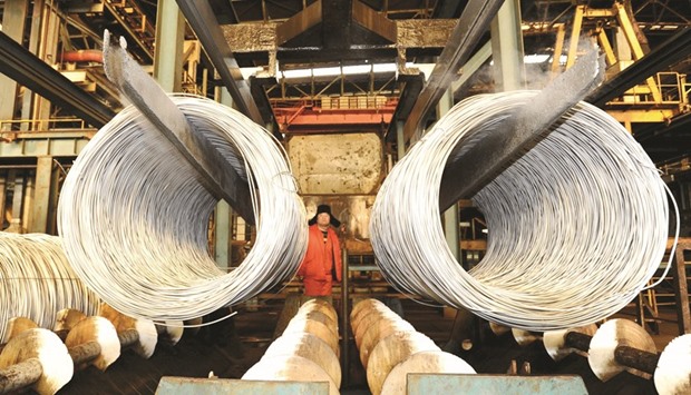 A worker stands near a stainless steel product line at a factory in Dalian, Liaoning province. Chinau2019s official manufacturing Purchasing Managersu2019 Index is expected to rise to 49.3 in March from 49.0 a month earlier, according to a median forecast of 32 economists in a Reuters poll.