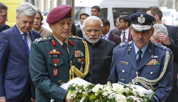 Belgium's Foreign Minister Didier Reynders (left) and Narendra Modi pay tribute to bomb attack victims at a street memorial outside Maalbeek metro station in Brussels on Wednesday.