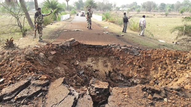 Police officials inspect a giant crater created by the blast yesterday.